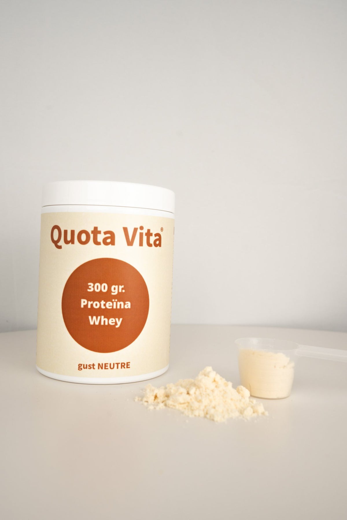 Pot de proteïna whey Quota Vita gust neutre amb el cullerot i pols al davant